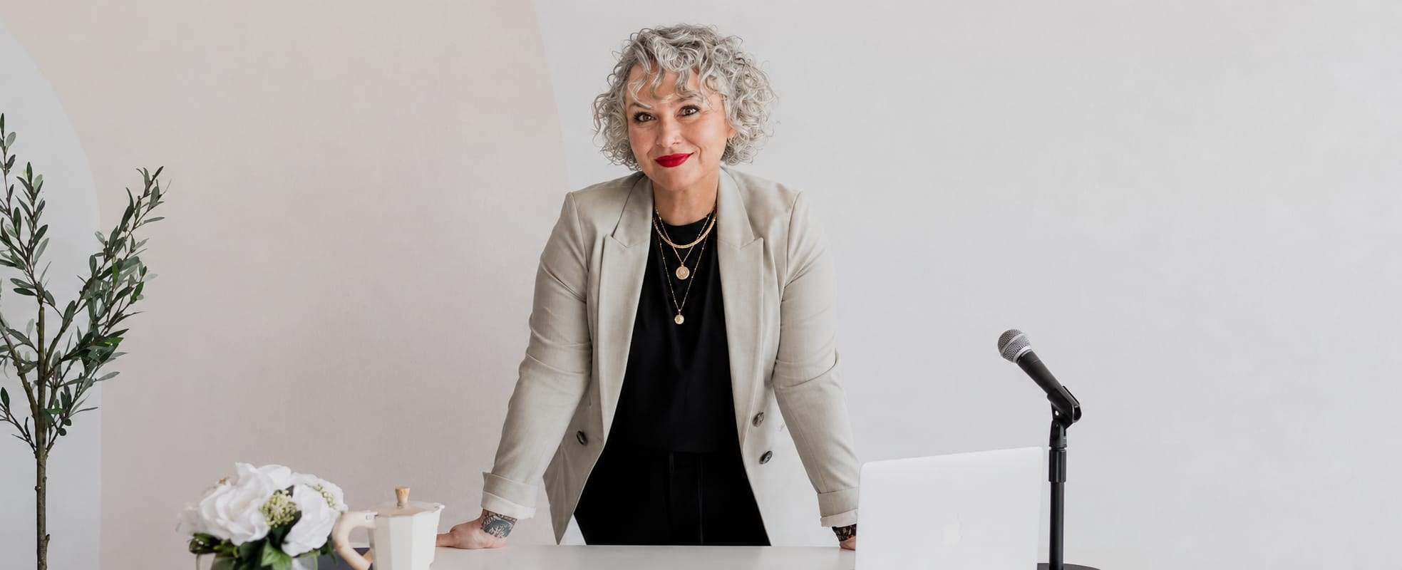 Nicole North standing at a desk with a laptop and microphone